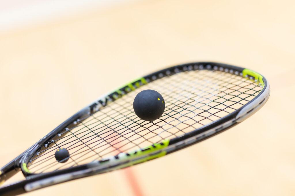 Squashschläger mit Squashball (doppelgelb) darauf)