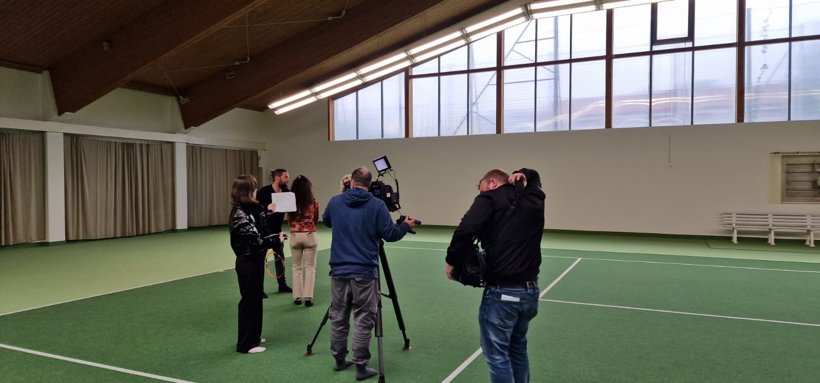 Filmteam mit Kameramann, Tontechniker, Licht, Darstellern auf dem Tennisplatz #10